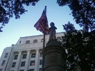 Caddo Courthouse monument with U.S. flag.